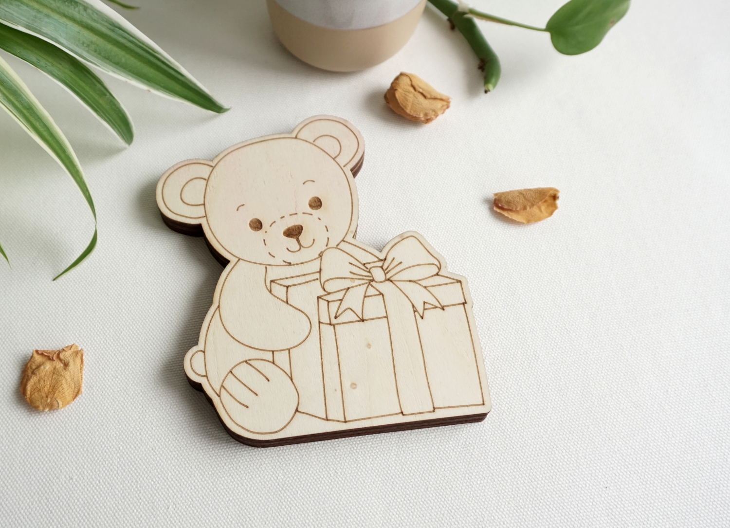 Sitzendes Bärchen mit Geschenk vor sich, aus hellem Holz. Seitlicher Schlitz, zum einstecken von gefalteten Geldscheinen oder Standard Geschenkkarten. dekorative Geschenkidee. Flach, aus drei lagen Holz. kann stehen oder liegen.